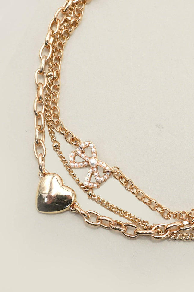 Multi-layer gold charm bracelet with heart charm and pearl bow on chain links, 7.5” with 2” extender