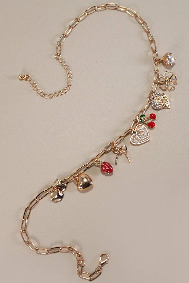 Gold chain necklace with various charms on a beige background