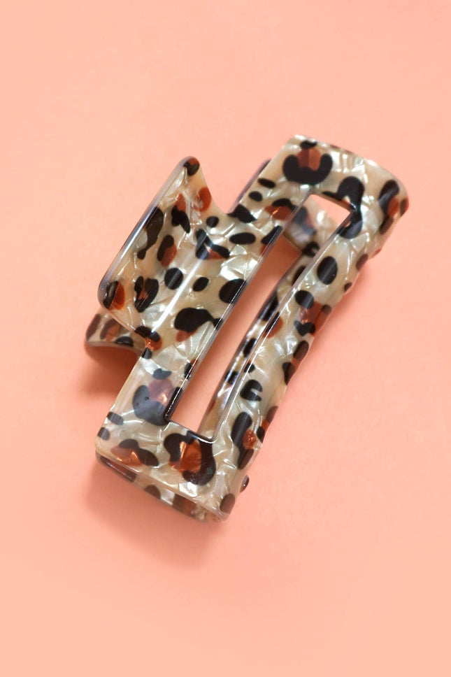 Leopard print hair clip on a pink background
