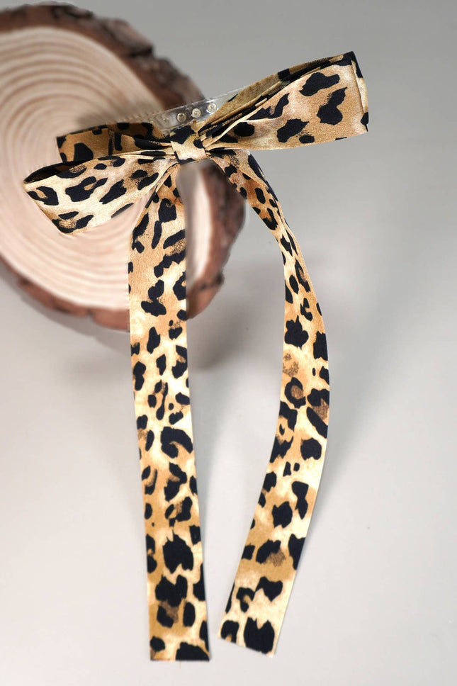 Leopard print ribbon tied into a bow on a neutral background