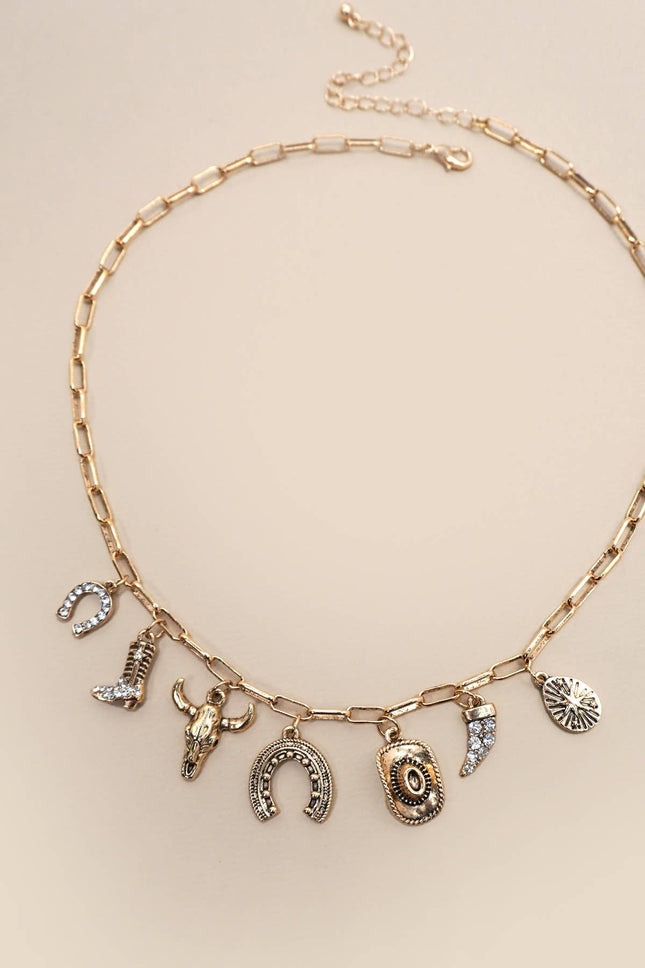 Gold necklace with various charms on a beige background