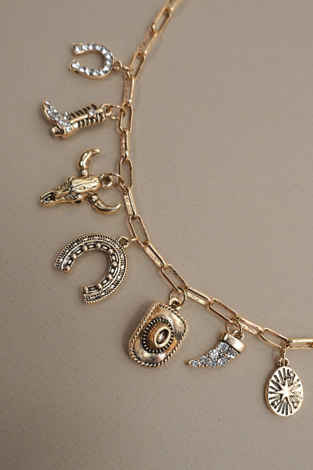 Gold necklace with various charms on a neutral background