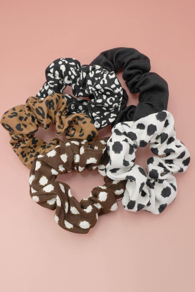 Set of five animal pattern scrunchies in mixed neutral prints displayed on a soft blush background, highlighting their stretchy, soft polyester fabric and assorted designs.