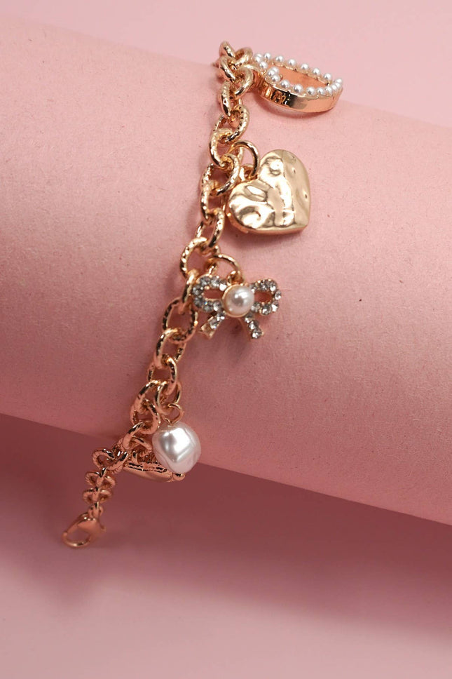 Gold-plated charm bracelet with bow, heart, pearl, and textured disc charms, 6.5” with 2” adjustable extender