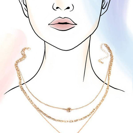 Layered gold necklace featuring delicate pearl strands and a small bow charm resting on a soft neutral background.