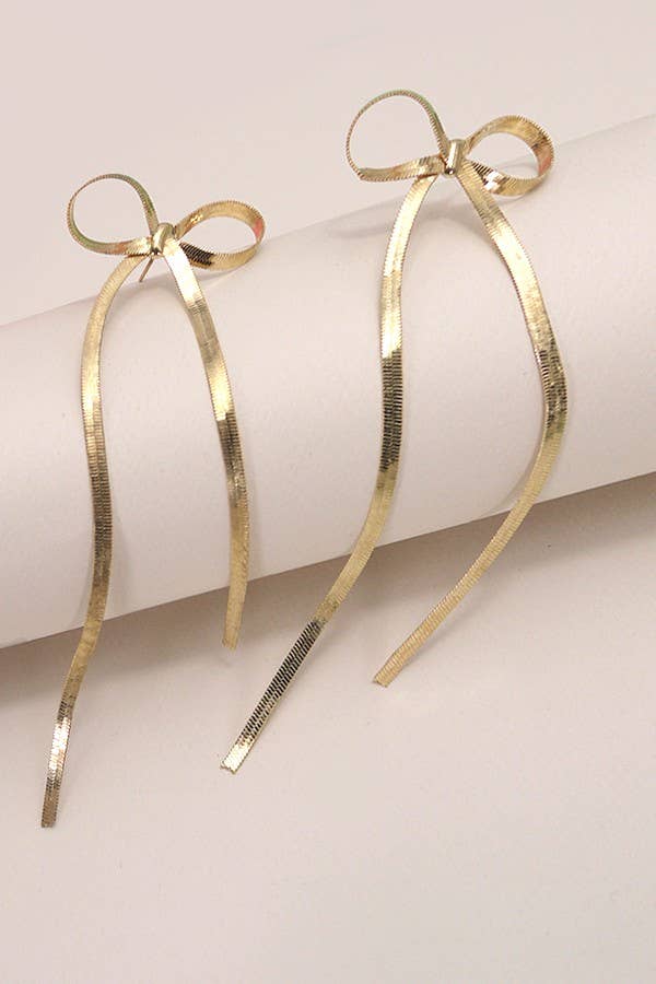 Gold bow-shaped earrings on a white background