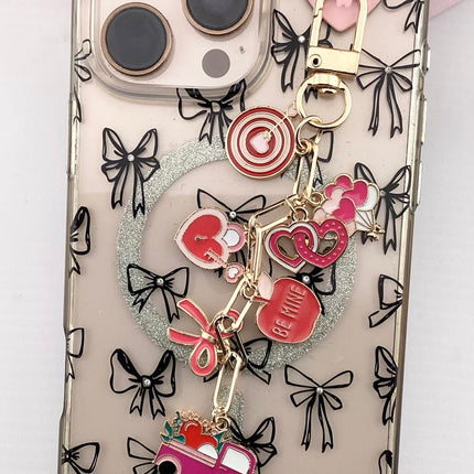 Phone case with charms and decorative elements on a light pink background