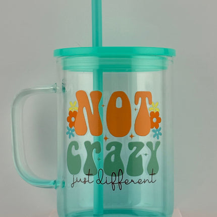 Clear tumbler with colorful text and a straw on a gray background