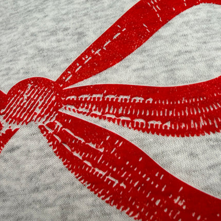 Light grey sweatshirt with pink bow graphic on chest, relaxed fit, drop shoulders, and ribbed hem and cuffs.