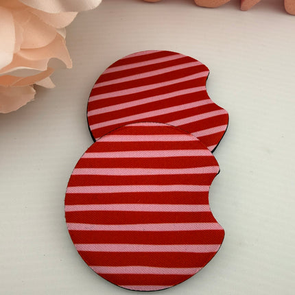 Two Valentine’s Day–themed neoprene car coasters with heart and love patterns, shown inside gift-ready packaging and styled on a neutral background.