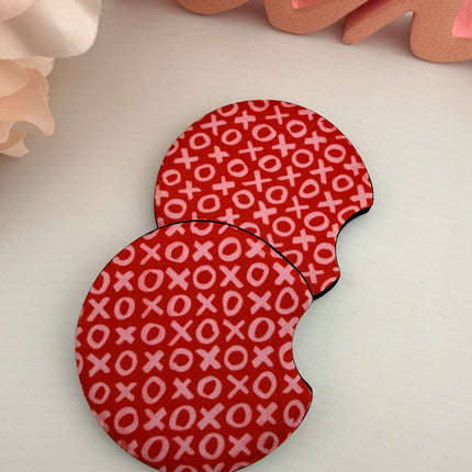Two Valentine’s Day–themed neoprene car coasters with heart and love patterns, shown inside gift-ready packaging and styled on a neutral background.