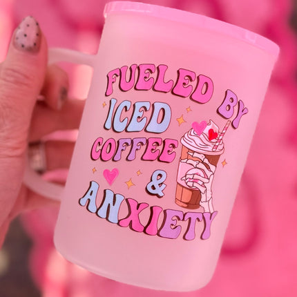Pink mug with 'Fueled by Iced Coffee & Anxiety' text and ice cream illustration against a pink background.