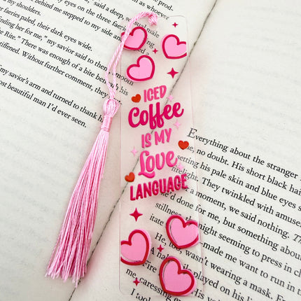 Handmade acrylic Valentine’s Day bookmarks featuring pink and red heart-themed designs with tassels, styled on open books for a cozy, festive reading aesthetic.