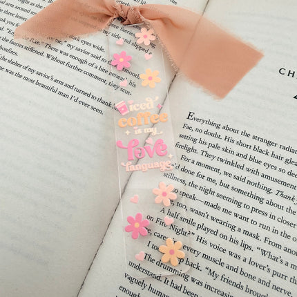 Clear acrylic Valentine’s Day bookmarks with pastel designs and soft chiffon ribbons resting inside open books, styled with a cozy, romantic bookish aesthetic.