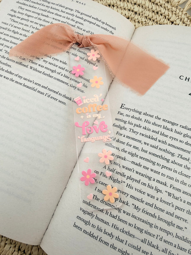 Clear acrylic Valentine’s Day bookmarks with pastel designs and soft chiffon ribbons resting inside open books, styled with a cozy, romantic bookish aesthetic.