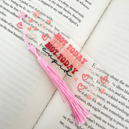 Handmade acrylic Valentine’s Day bookmarks featuring pink and red heart-themed designs with tassels, styled on open books for a cozy, festive reading aesthetic.