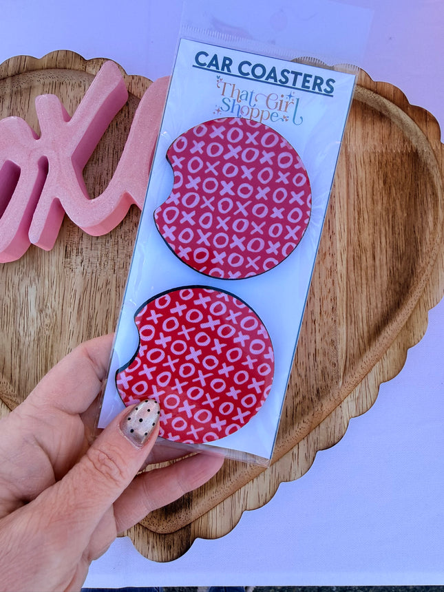 Two Valentine’s Day–themed neoprene car coasters with heart and love patterns, shown inside gift-ready packaging and styled on a neutral background.
