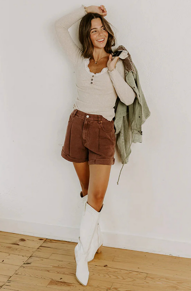 Beige ribbed knit top with lace trim neckline, button details, and lettuce-edge sleeves and hem, long sleeve fitted silhouette