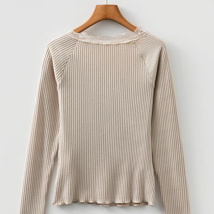 Beige ribbed knit top with lace trim neckline, button details, and lettuce-edge sleeves and hem, long sleeve fitted silhouette