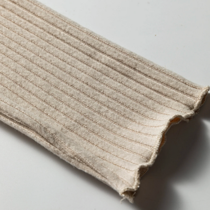 Beige ribbed knit top with lace trim neckline, button details, and lettuce-edge sleeves and hem, long sleeve fitted silhouette