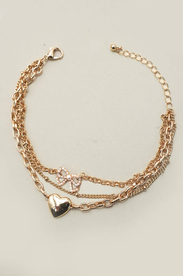 Multi-layer gold charm bracelet with heart charm and pearl bow on chain links, 7.5” with 2” extender