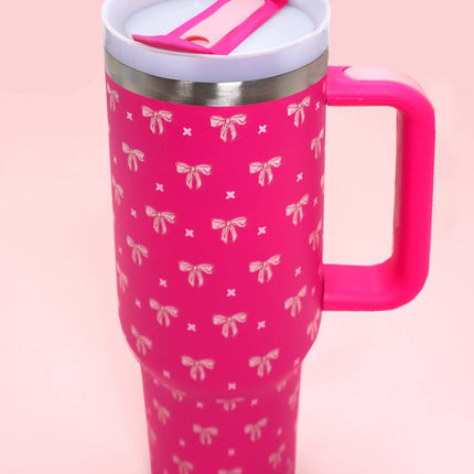 Pink mug with bow pattern and pink handle on a pink background