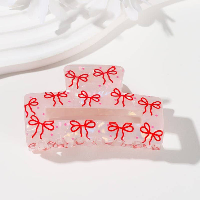 Transparent hair clips with red bow designs on a white background