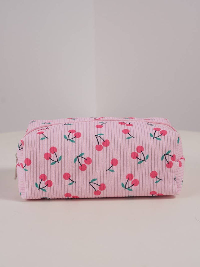 Pink toiletry bag with cherry pattern on a light gray background