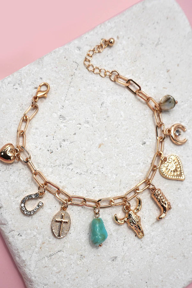 Gold western-themed charm bracelet with boot, bullhead, horseshoe, moon, heart, and stone accents on adjustable chain