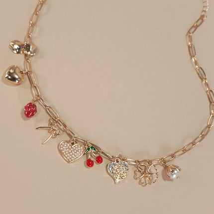 Gold necklace with various charms on a beige background