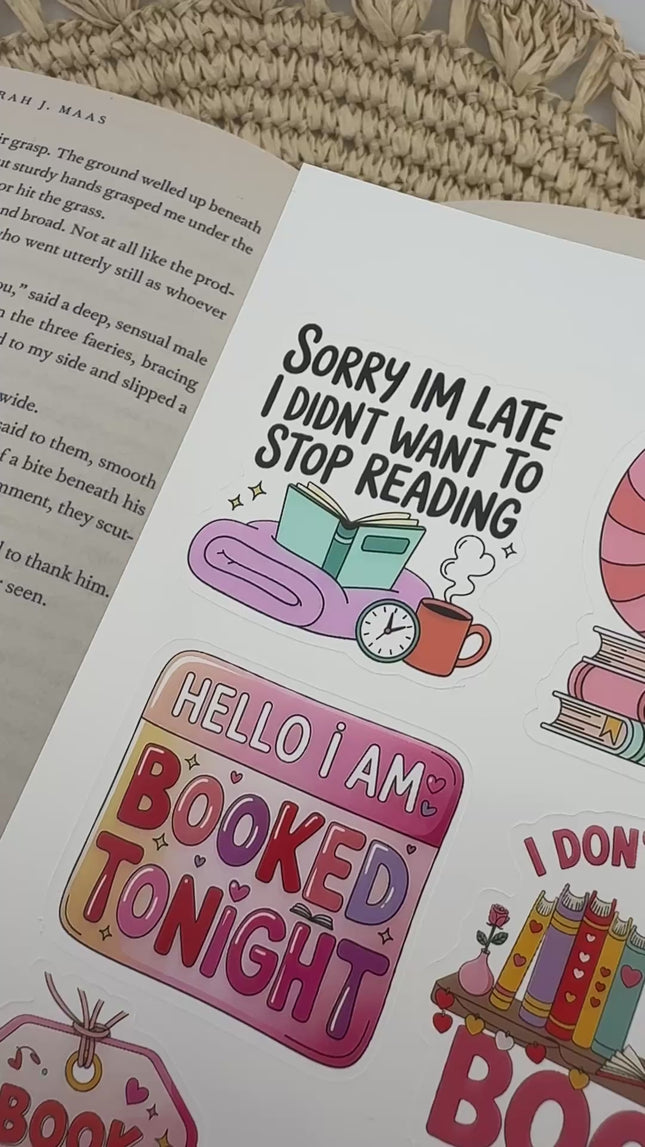 Multiple book lover sticker sheet designs featuring cozy reading themes, spicy book humor, hearts, books, and playful illustrations displayed on an open book background.