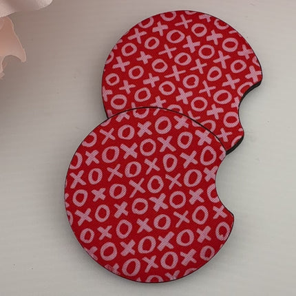 Two Valentine’s Day–themed neoprene car coasters with heart and love patterns, shown inside gift-ready packaging and styled on a neutral background.