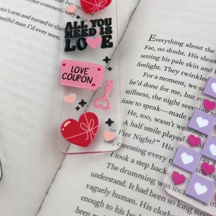 Clear acrylic Valentine’s Day bookmarks with pastel designs and soft chiffon ribbons resting inside open books, styled with a cozy, romantic bookish aesthetic.