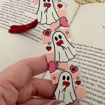 Handmade acrylic Valentine’s Day bookmarks featuring pink and red heart-themed designs with tassels, styled on open books for a cozy, festive reading aesthetic.